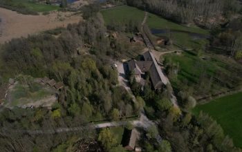A stunning aerial shot of the ancient Biskupin village in Poland, surrounded by lush greenery.